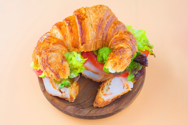 Sandwich mit Croissant aus Salat, Tomate und geräuchertem Truthahn