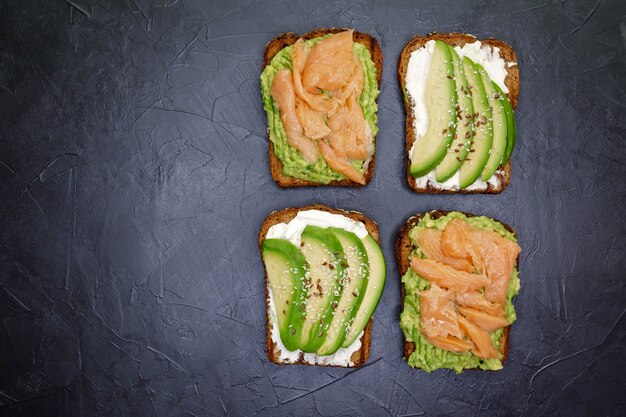 Sandwich mit dunklem Roggenbrot, Avocado und geräuchertem Lachs