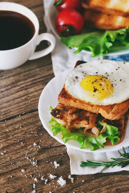 Sandwich mit Eiern, Huhn, Gurke und Kopfsalat auf einem hölzernen Hintergrund kopieren Raum