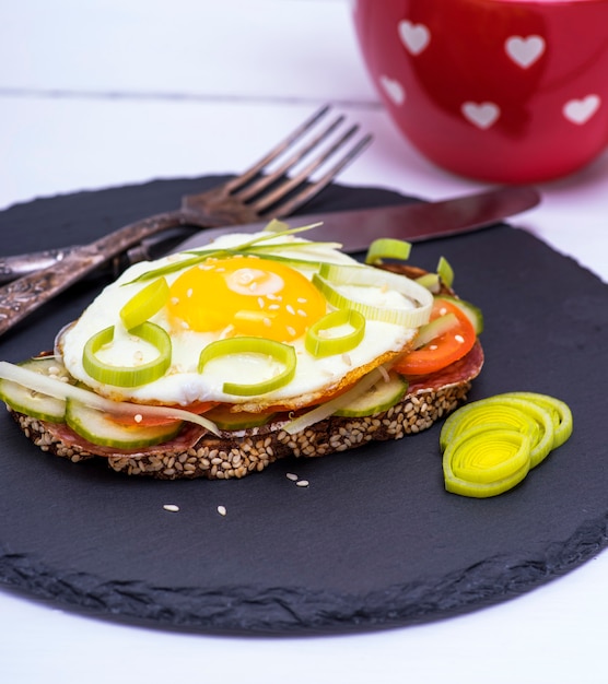 Sandwich mit einer Scheibe Roggenbrot und Spiegelei