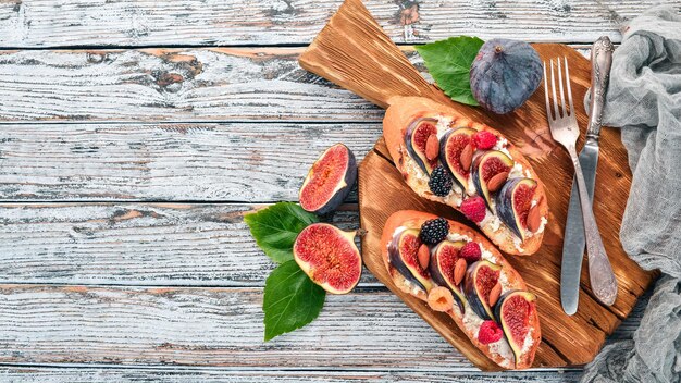 Sandwich mit Feigen Waldbeeren und Käse Auf dem alten Hintergrund Dessert Freier Platz für Text Ansicht von oben