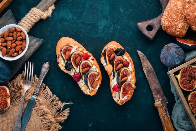 Sandwich mit Feigen Waldbeeren und Käse Auf dem alten Hintergrund Dessert Freier Platz für Text Ansicht von oben