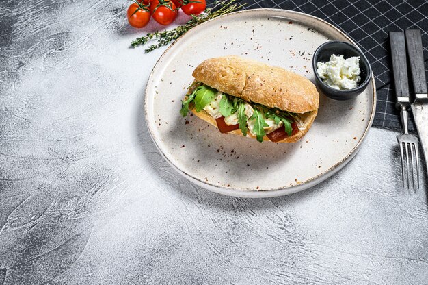 Sandwich mit frischem Camembertkäse, Birnenmarmelade, Ricotta und Rucola. Graue Oberfläche. Draufsicht. Platz für Text