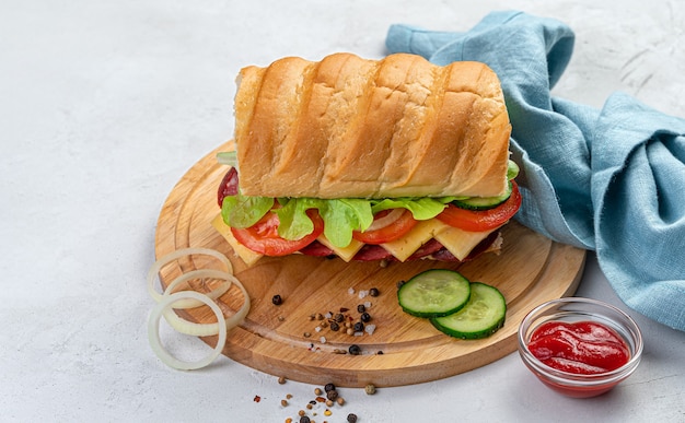 Sandwich mit frischem Gemüse, Käse und Wurst auf grauem Hintergrund mit Zutaten with