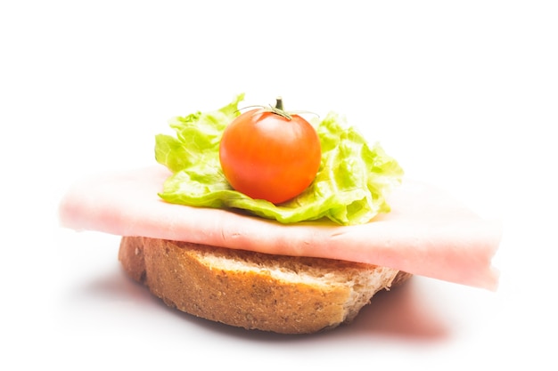 Sandwich mit frischer Schinkenscheibe, Lattuce und Cherrytomaten auf Weiß