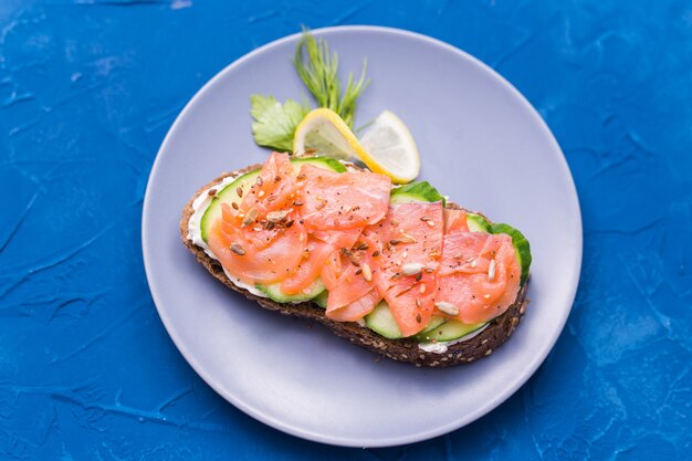 Foto sandwich mit geräuchertem lachs und gurke. konzept für eine gesunde ernährung.