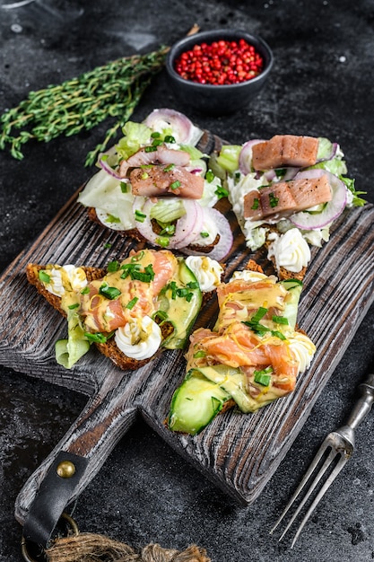 Sandwich mit geräuchertem Lachs und Hering mit Frischkäse und Salat