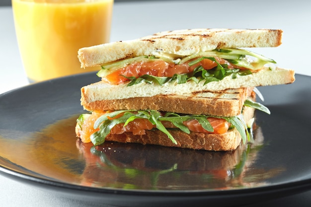 Sandwich mit Lachs zum Frühstück mit Orangensaft