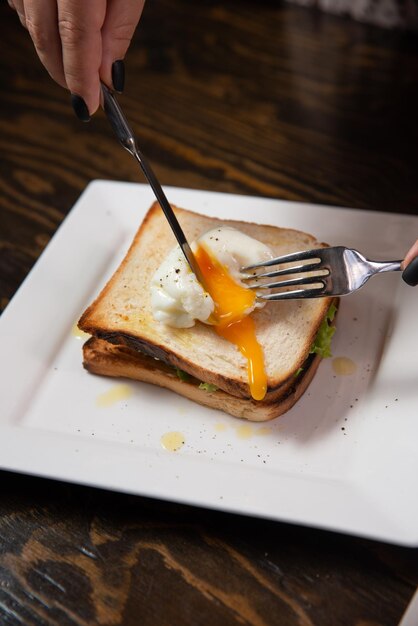 Sandwich mit pochiertem Ei und Schinken isoliert auf grünem Hintergrund kopieren Raum hautnah