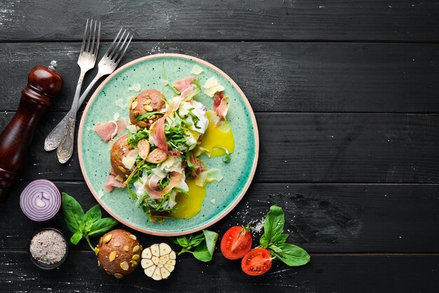 Sandwich mit Proshutto-Ei und Rucola Frühstück auf dem Teller Draufsicht Flache Laienzusammensetzung Freier Kopierbereich