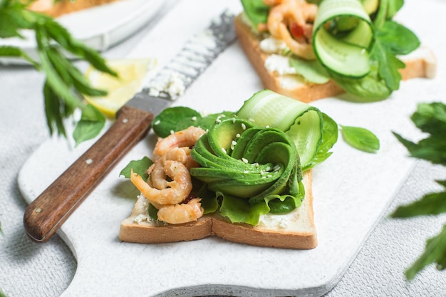 Sandwich mit Sahne, Käse, Garnelen, Avocado und Gurke