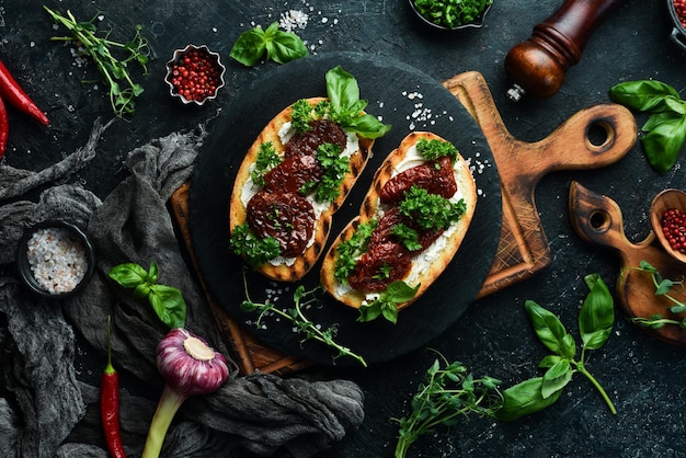 Sandwich mit sonnengetrockneten Tomaten, Käse und Basilikum Bruschetta Draufsicht auf einem Steinhintergrund