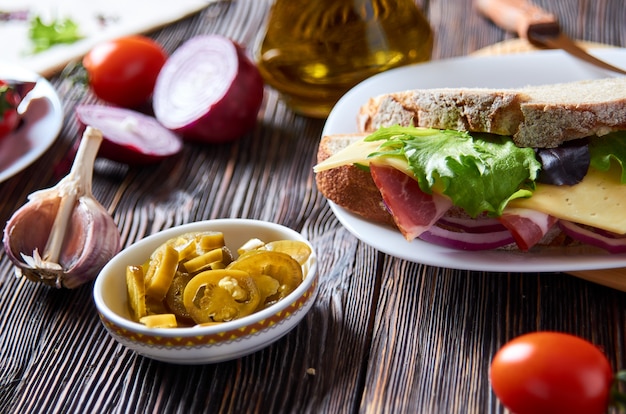 Sandwich mit Speck, Käse, Knoblauch, Jalapenopfeffer und Kräutern auf einem Teller