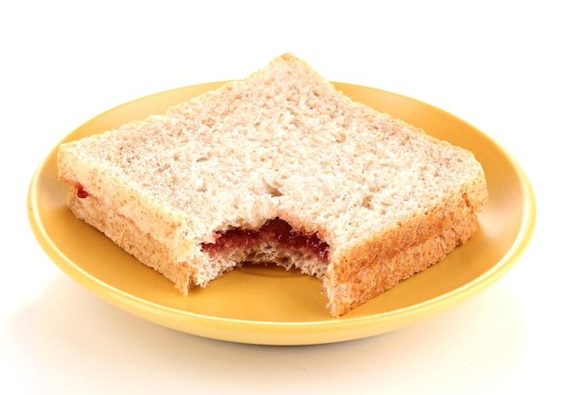 Sándwich mordido con mermelada en un plato aislado en blanco