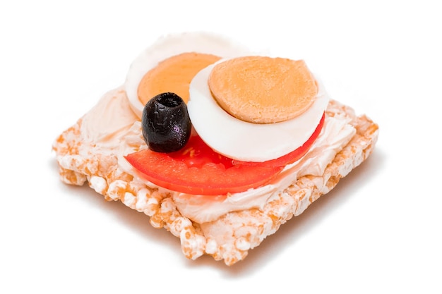 Sándwich de pastel de arroz con huevos de tomate y aceitunas aislado