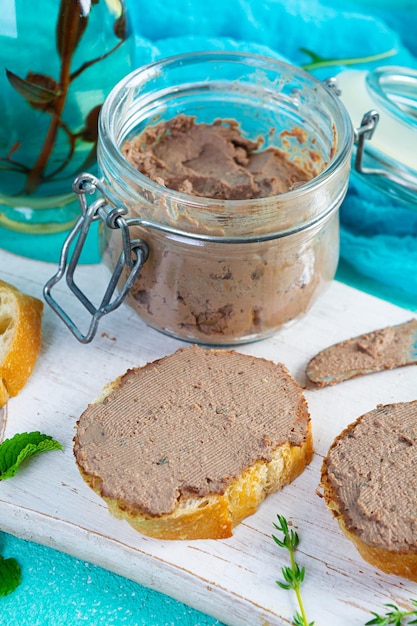 Sandwich con paté de hígado de pollo sobre fondo azul.