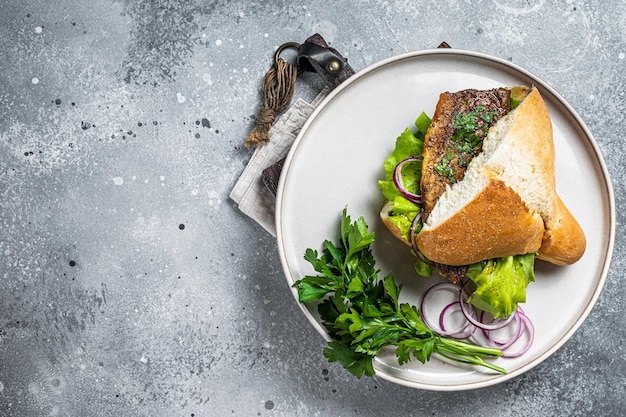 Sándwich de pescado turco Balik Ekmek con filete de caballa a la parrilla en un bollo Fondo gris Vista superior Espacio de copia