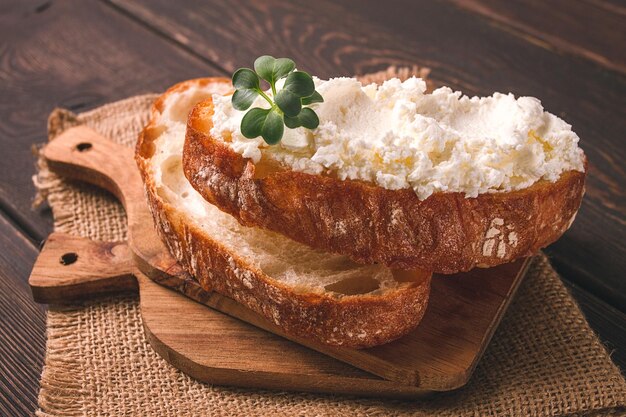 Sándwich con queso crema casero en una tabla de cortar estilo rústico sin gente desayuno de enfoque selectivo