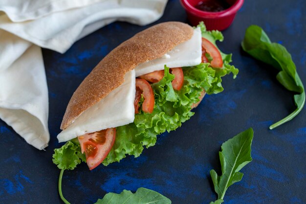 Sándwich con queso feta, tomate, lechuga, rúcula, entre pan integral, merienda rápida, sabroso sándwich