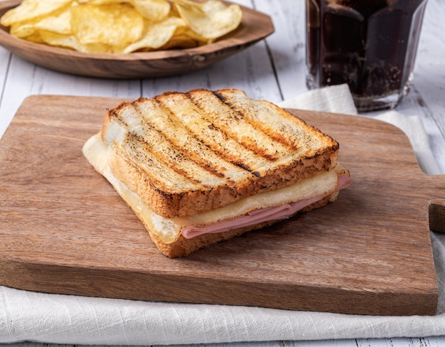 Sándwich de queso y jamón con papas fritas y refresco