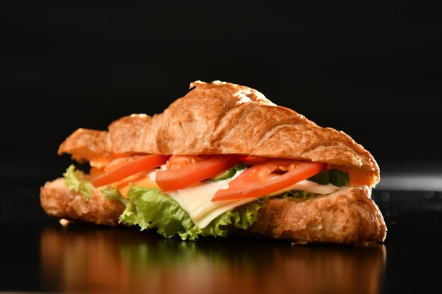 Foto un sándwich con queso, lechuga, tomate y lechuga.