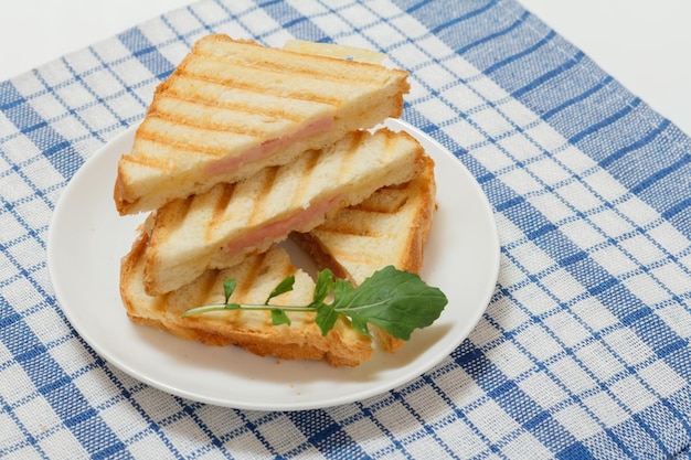 Sándwich de queso a la parrilla casero para el desayuno en un plato en la servilleta