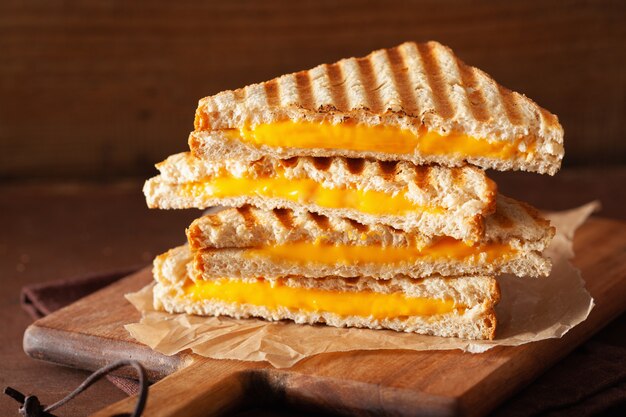 Sandwich de queso a la parrilla sobre fondo marrón rústico