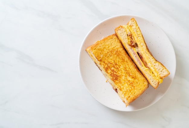 Sándwich de queso, tocino, jamón y tostadas francesas caseras con huevo