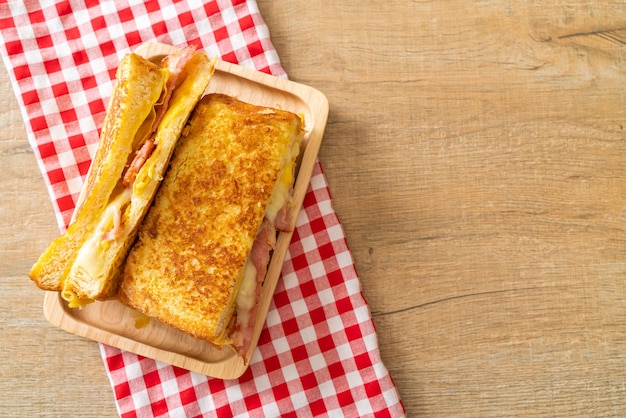 Sándwich de queso, tocino, jamón y tostadas francesas caseras con huevo