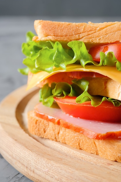 Sándwich sabroso con jamón, ensalada, queso y tomates