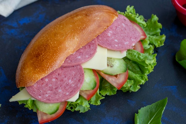 Sándwich con salami cheddar tomate pepino lechuga rúcula en pan merienda rápida delicioso sándwich