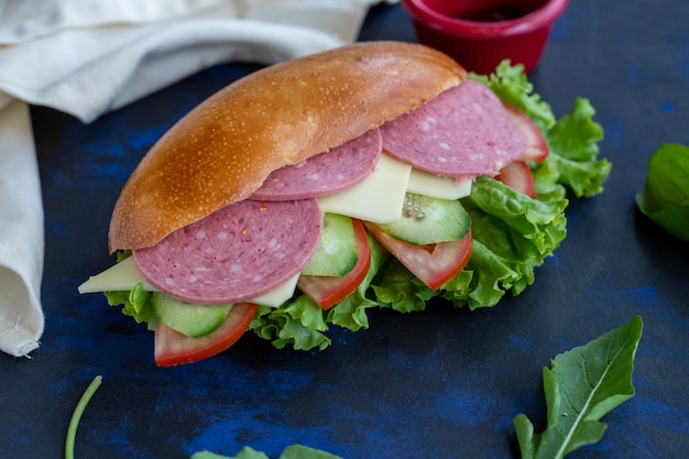 Foto sándwich con salami cheddar tomate pepino lechuga rúcula en pan merienda rápida delicioso sándwich