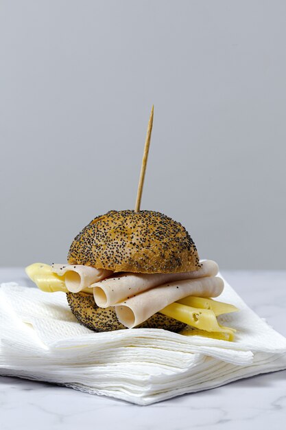 Sándwich de salchicha casera con lechuga y queso con pan de semillas. Quitar. Entrega de comida