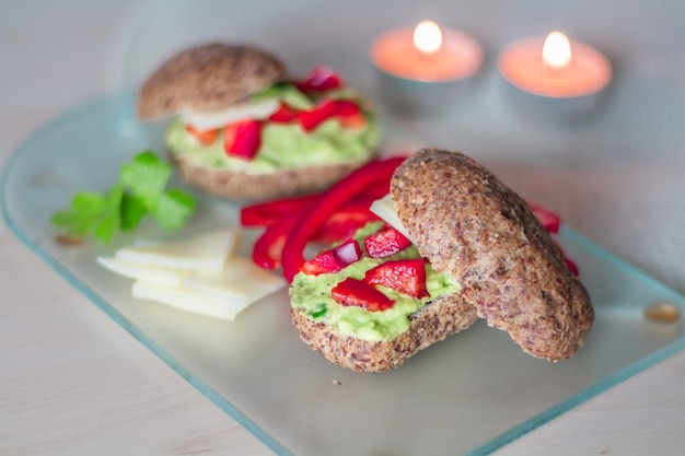 Sándwich saludable con avokado y queso en el tablero de vidrio