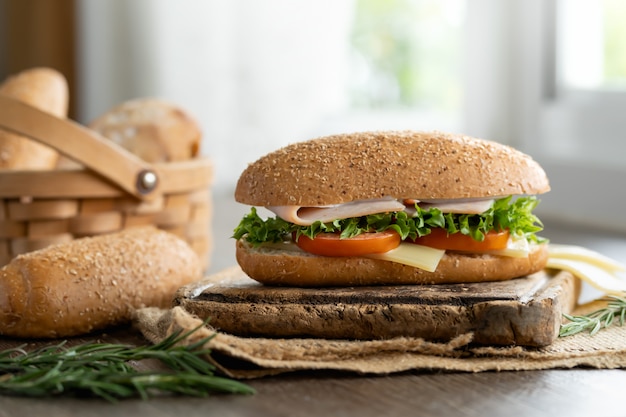 Sandwich Schinken und Käse mit Sesambrot und Toastbrot auf Korb.