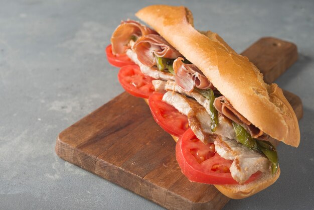 Sandwich Serranito típico de Andalucía con jamón, pimiento y lomo de cerdo a la plancha