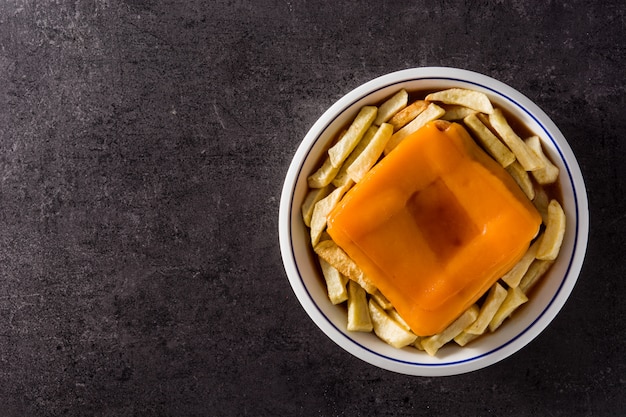 Sándwich típico francés francesinha con papas fritas en negro