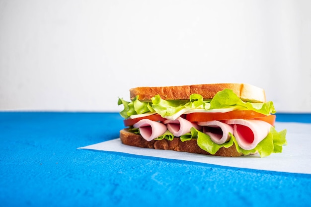 Sándwich con tocino, tomates y hierbas.