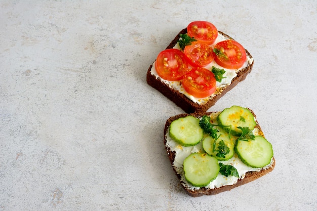 Un sándwich con tomate de pepino y perejil picado en un espacio de copia de mesa gris