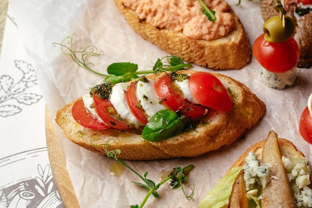 Un sándwich con tomates y queso encima.