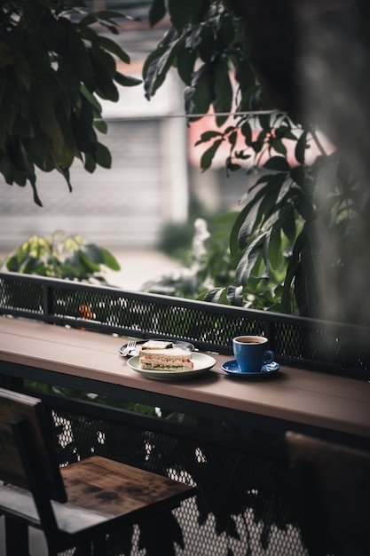 Sandwich und heißer Kaffee auf Holzbar