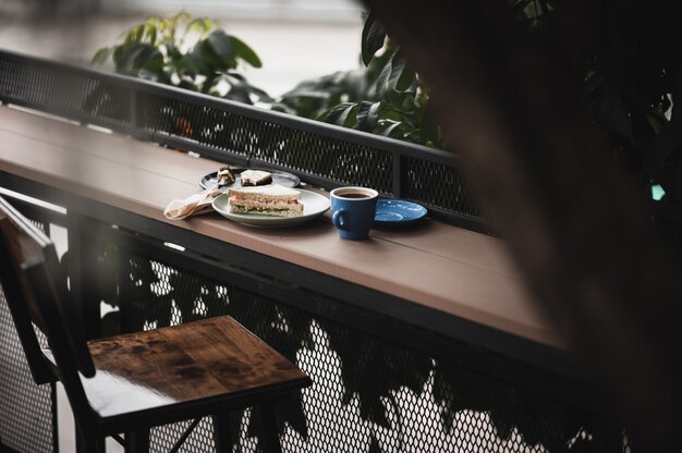 Sandwich und heißer Kaffee auf Holzbar