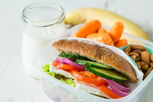 Sándwich vegano en lonchera con zanahorias y nueces