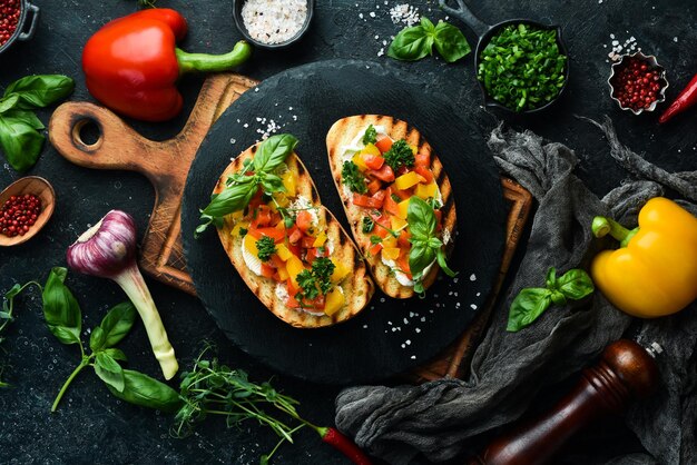 Sándwich vegano con pimientos dulces queso verduras y albahaca Bruschetta Vista superior sobre un fondo de piedra