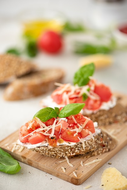 Foto sandwich vegetariano con tomates rosados, parmesano y albahaca