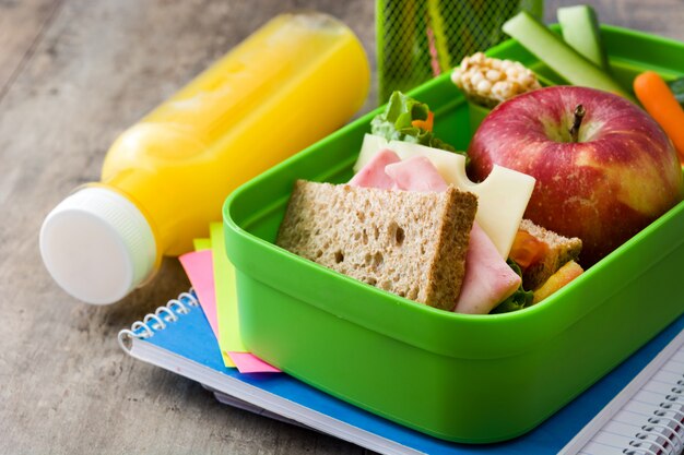 Sandwich, verduras, frutas y jugo en la mesa de madera