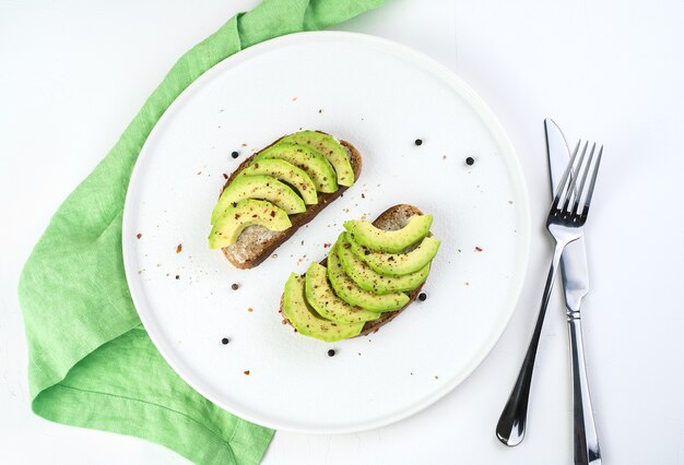 Sándwiches de aguacate y especias en una placa blanca.