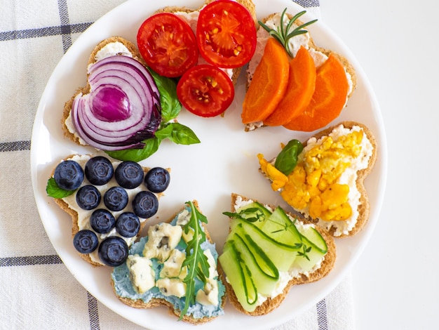 Sándwiches de arco iris en forma de corazón en mesa blanca