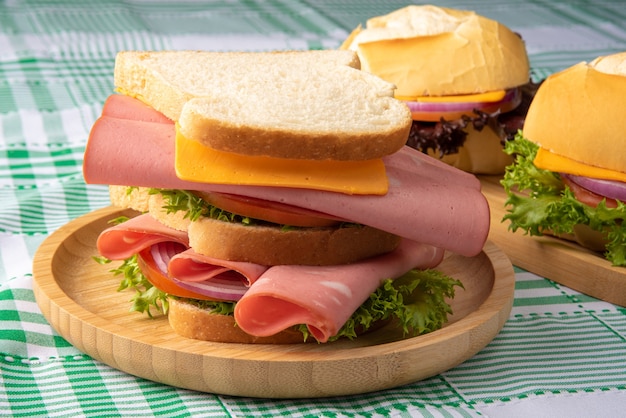 Sandwiches auf einem Holzteller auf grün-weiß karierter Tischdecke