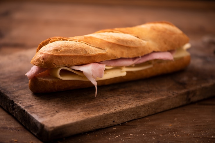 Foto sándwiches de baguette en mesa rústica cerrar